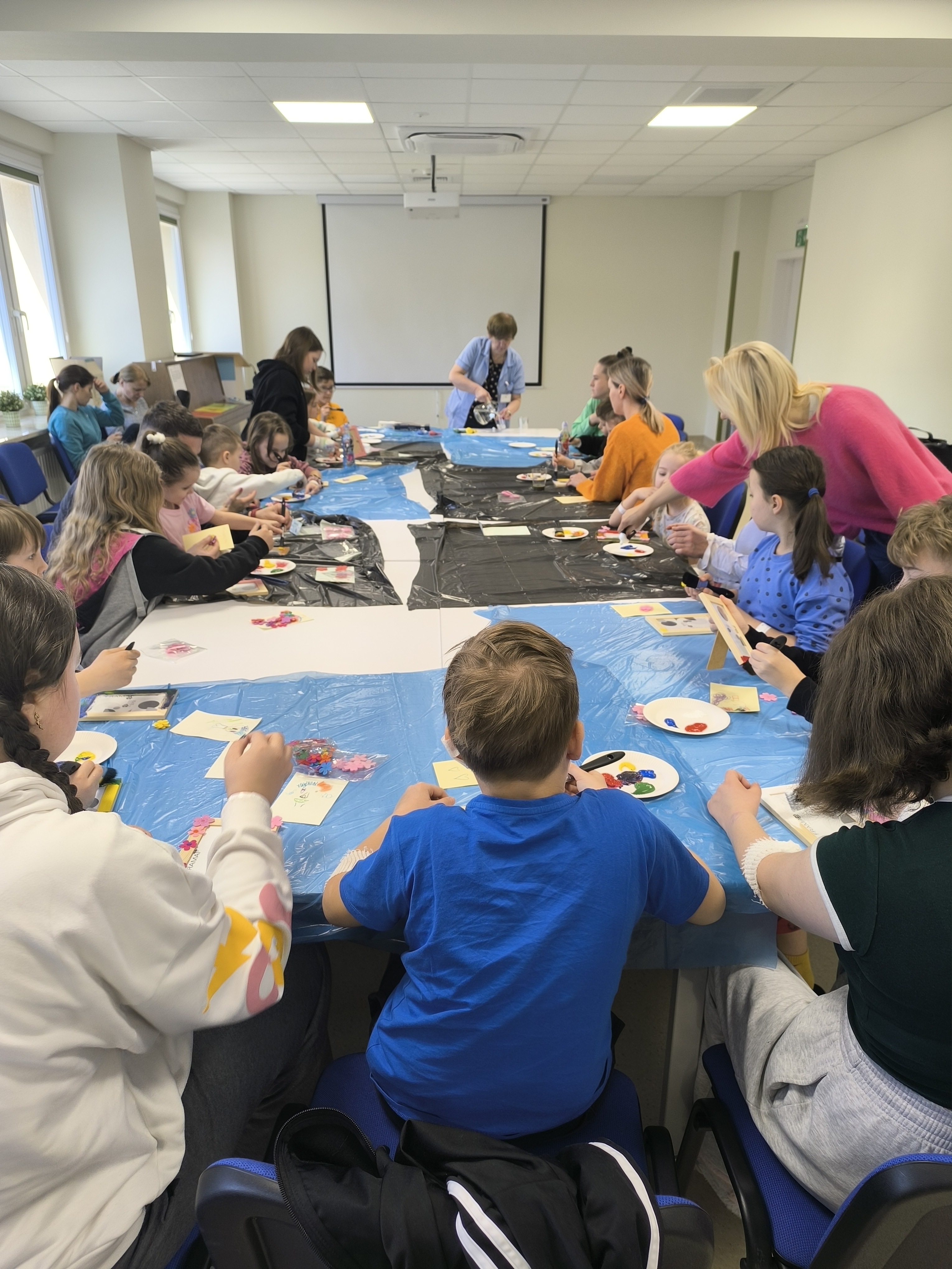 Grupa dzieci wykonuje prace plastyczne